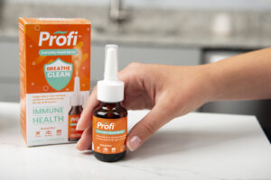 hand picking up nasal spray sitting next to product box on kitchen counter product photo