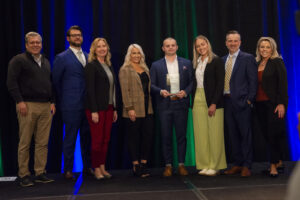 award winning team poses for a photo on stage during the event photography coverage for the Conway Family Business Awards 2023