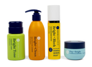 four bright girl beauty products standing next to each other on a white background