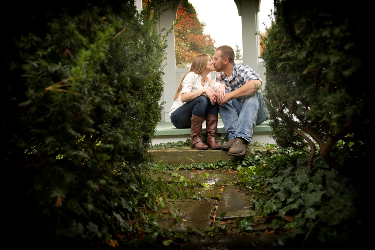 Engagement Photography - Couple kissing between vines and bushes in Autumn